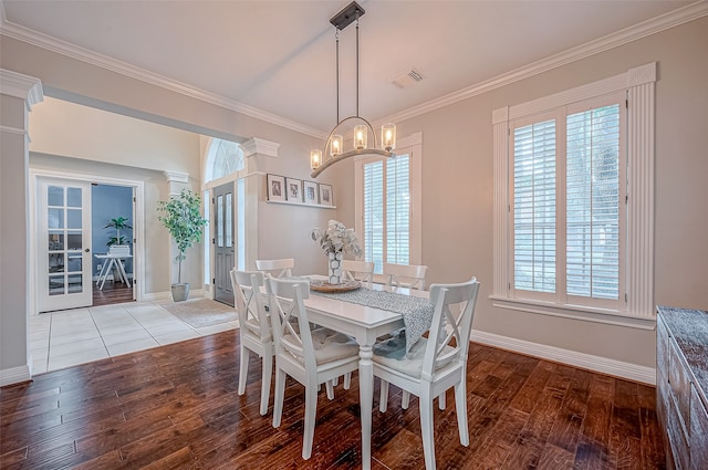 dining space with light hardwood / wood-style flooring, a notable chandelier, and crown molding