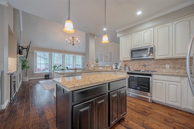 kitchen featuring appliances with stainless steel finishes, kitchen peninsula, pendant lighting, dark wood-type flooring, and ornamental molding