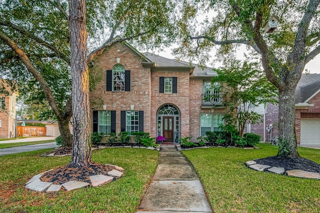 view of front of home with a balcony, a front yard, and a garage