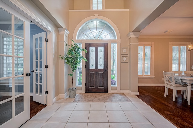 foyer entrance with light hardwood / wood-style floors, crown molding, and plenty of natural light