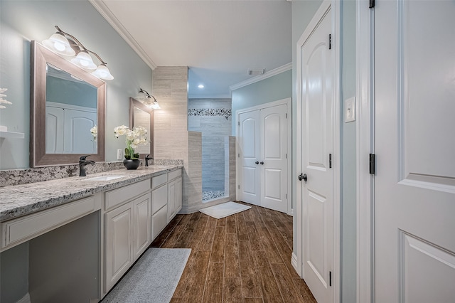 bathroom featuring vanity, hardwood / wood-style floors, walk in shower, and ornamental molding