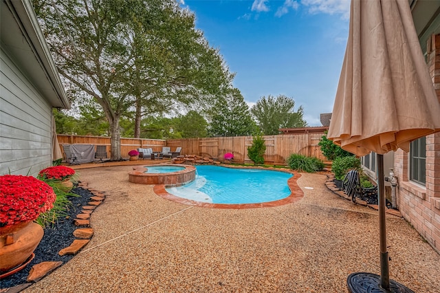 view of swimming pool featuring a patio area and an in ground hot tub