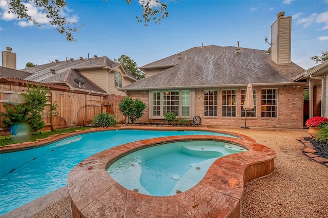 view of swimming pool with an in ground hot tub