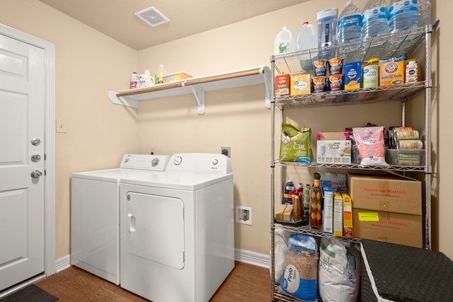 laundry area with washer and dryer and wood-type flooring