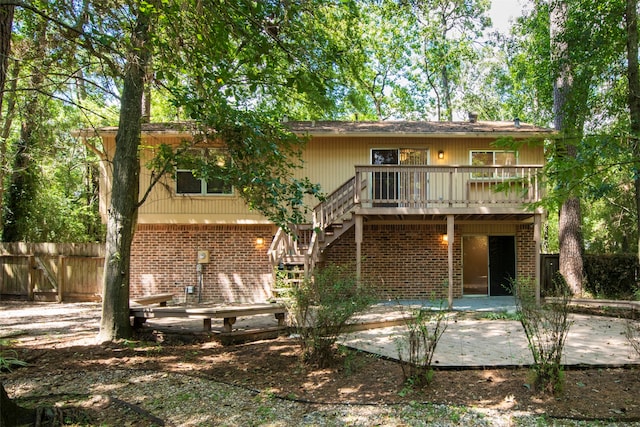 back of house with a wooden deck and a patio area