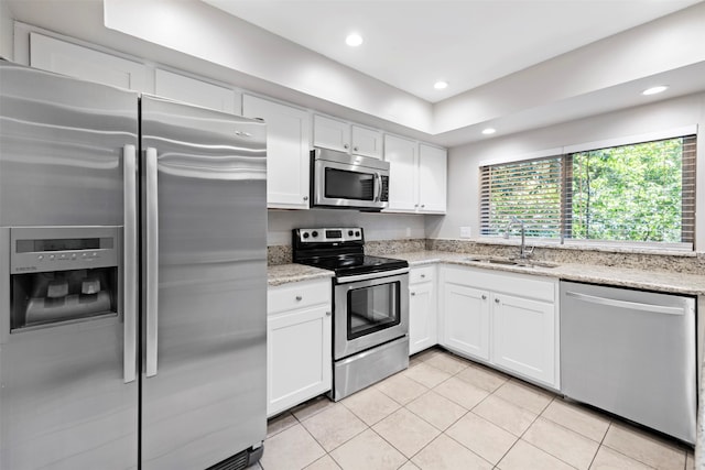 kitchen featuring white cabinetry, light tile patterned flooring, appliances with stainless steel finishes, and sink