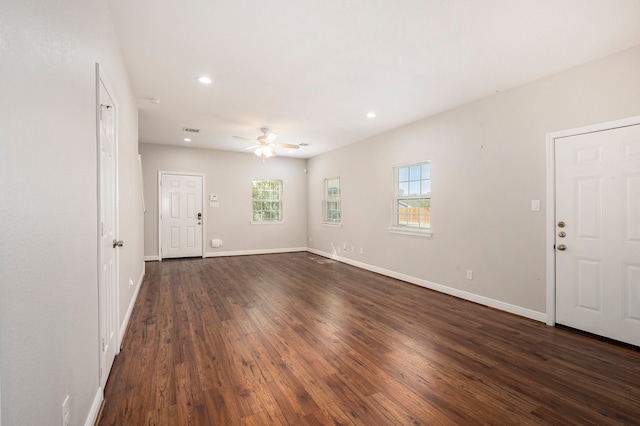 interior space featuring ceiling fan, a wealth of natural light, and dark hardwood / wood-style flooring