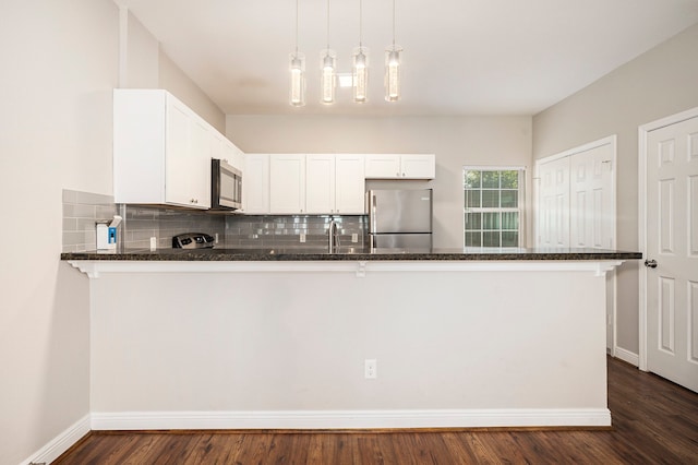 kitchen featuring white cabinets, kitchen peninsula, stainless steel appliances, and dark hardwood / wood-style floors