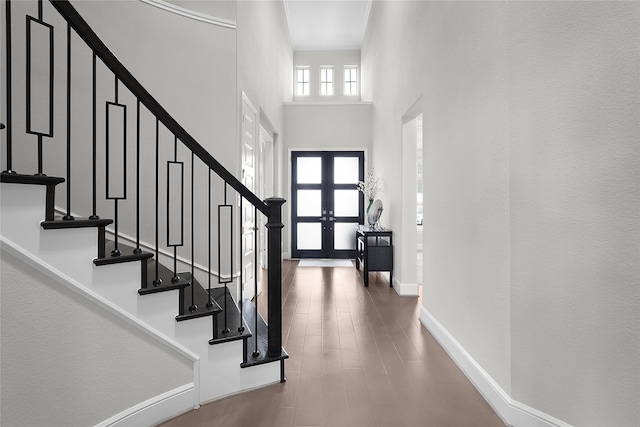 entrance foyer with a towering ceiling, french doors, and hardwood / wood-style flooring