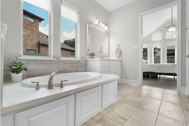 bathroom featuring a bathing tub, lofted ceiling, tile walls, vanity, and tile patterned flooring