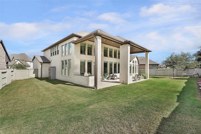 rear view of property featuring a yard and a patio area