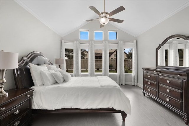 bedroom featuring light hardwood / wood-style flooring, lofted ceiling, crown molding, and ceiling fan