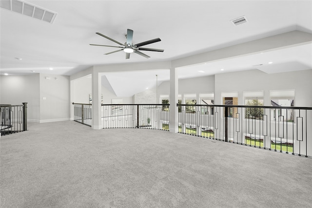 carpeted empty room with vaulted ceiling and ceiling fan