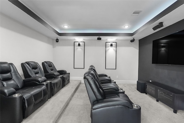 carpeted home theater room featuring a raised ceiling