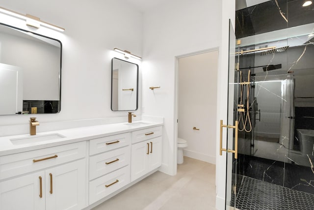 bathroom with vanity, toilet, and a shower with door