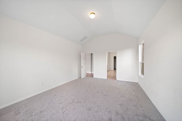 unfurnished bedroom featuring light colored carpet and vaulted ceiling