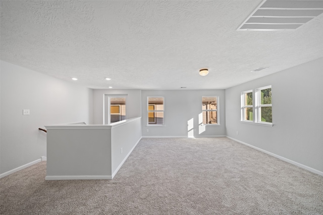 carpeted spare room featuring a textured ceiling