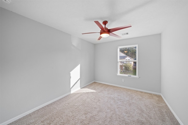 spare room featuring light carpet and ceiling fan