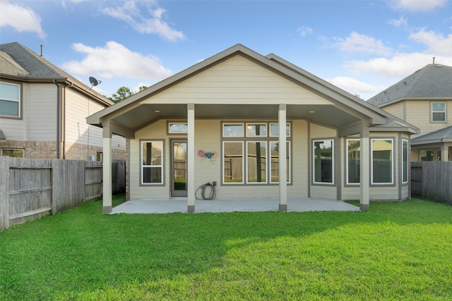 back of house featuring a lawn and a patio area