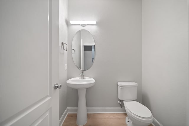 bathroom with wood-type flooring and toilet