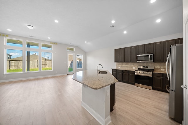 kitchen featuring a kitchen island with sink, light hardwood / wood-style flooring, lofted ceiling, and appliances with stainless steel finishes