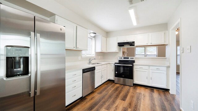 kitchen with white cabinets, stainless steel appliances, sink, and dark hardwood / wood-style floors