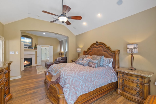 bedroom with lofted ceiling, multiple windows, ceiling fan, and dark hardwood / wood-style floors