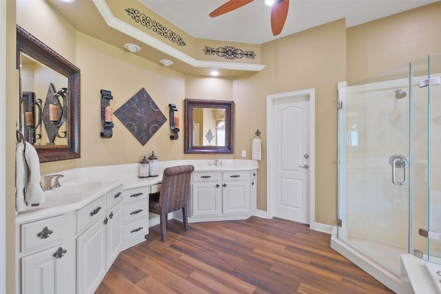 bathroom with vanity, ceiling fan, a shower with shower door, and wood-type flooring