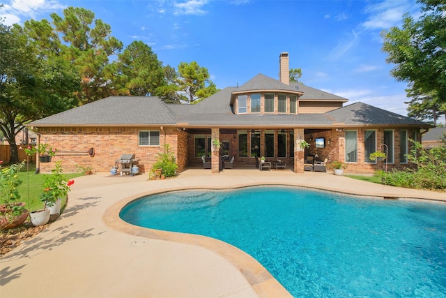 view of pool with area for grilling and a patio area