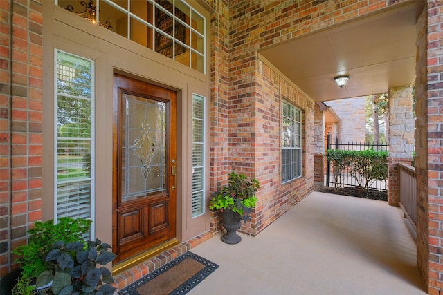 view of exterior entry featuring covered porch