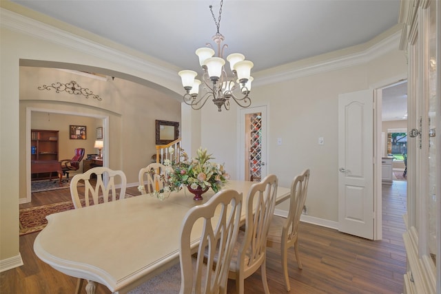 dining room with dark hardwood / wood-style flooring, crown molding, and a chandelier