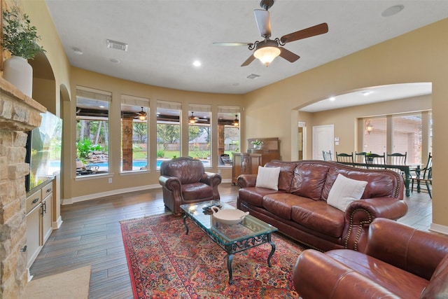 living room featuring ceiling fan and dark wood-type flooring