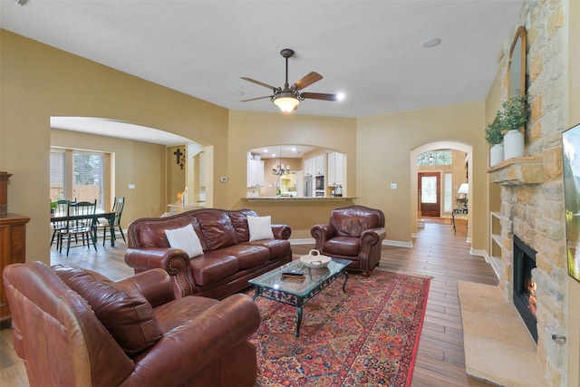 living room with a fireplace, hardwood / wood-style flooring, and ceiling fan