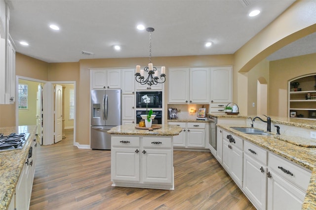 kitchen featuring white cabinets, sink, hanging light fixtures, and black appliances