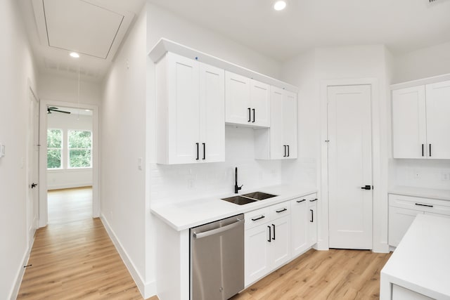 kitchen featuring stainless steel dishwasher, white cabinetry, and sink