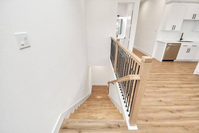 stairs featuring wood finished floors and baseboards