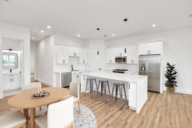 dining room featuring light wood-style floors, baseboards, and recessed lighting