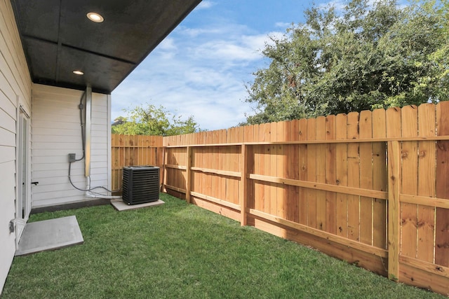 view of yard featuring fence and central air condition unit