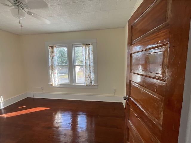 unfurnished room with ceiling fan and dark hardwood / wood-style flooring