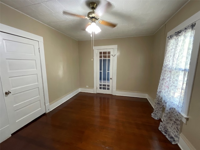 unfurnished room featuring crown molding, dark hardwood / wood-style floors, and ceiling fan