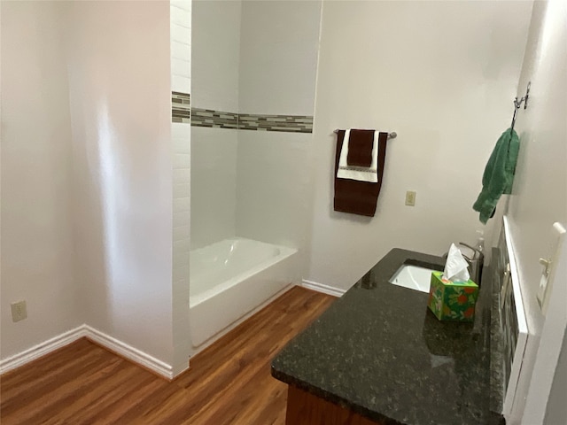 bathroom featuring vanity, a tub to relax in, and hardwood / wood-style flooring