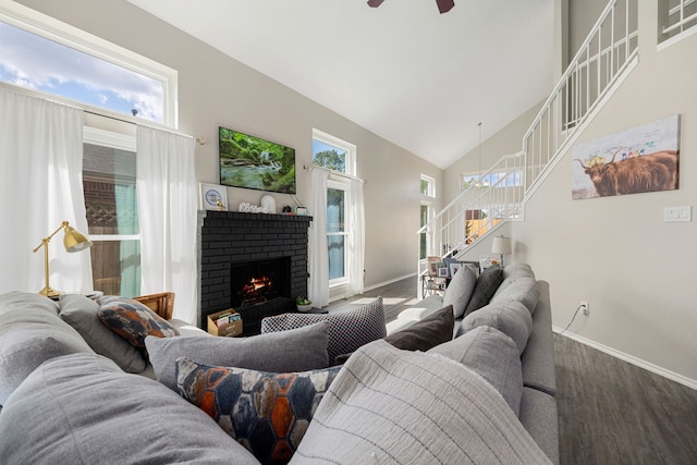 living room with hardwood / wood-style floors, a brick fireplace, high vaulted ceiling, and a healthy amount of sunlight