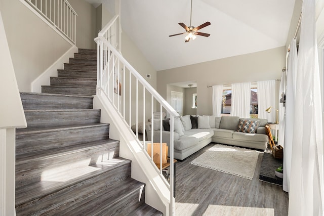 staircase featuring hardwood / wood-style flooring, high vaulted ceiling, and ceiling fan