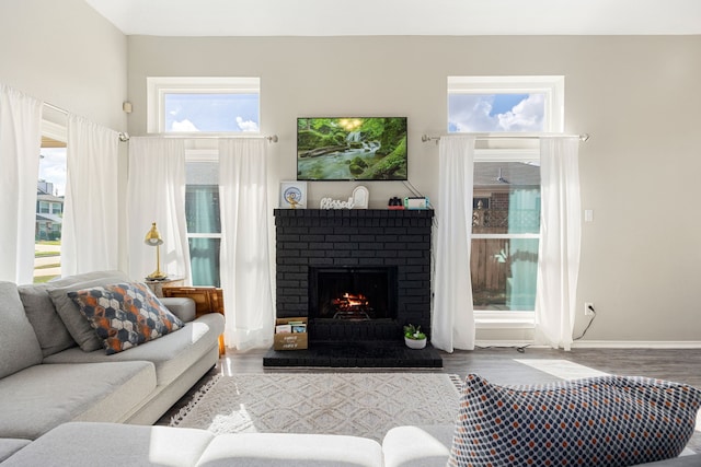 living room with hardwood / wood-style flooring and a brick fireplace