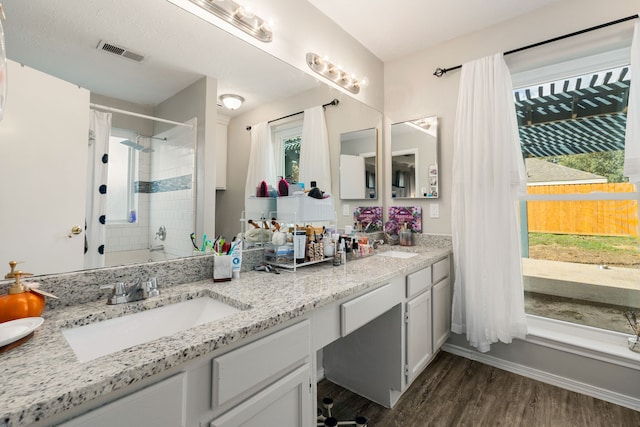 bathroom with a shower with door, vanity, and wood-type flooring