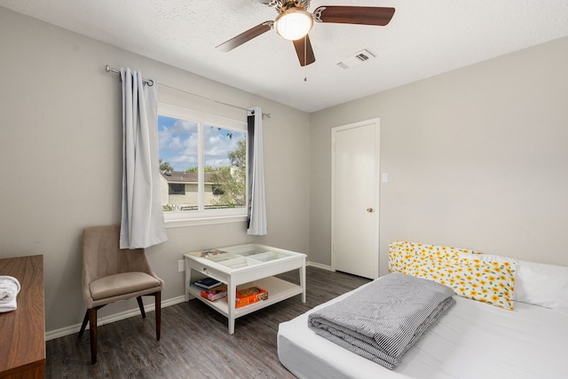 bedroom featuring ceiling fan, a textured ceiling, and dark hardwood / wood-style floors