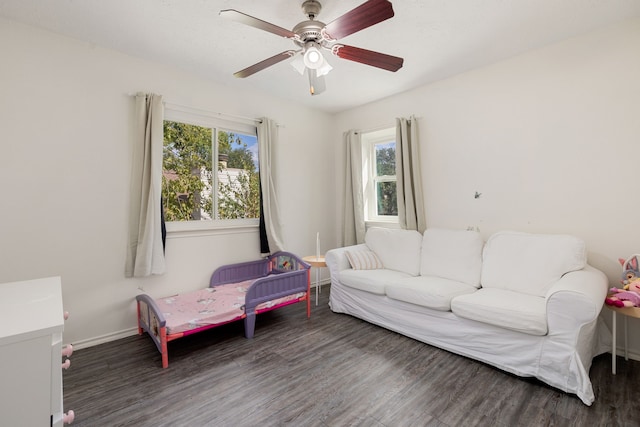 living room featuring dark wood-type flooring, a healthy amount of sunlight, and ceiling fan