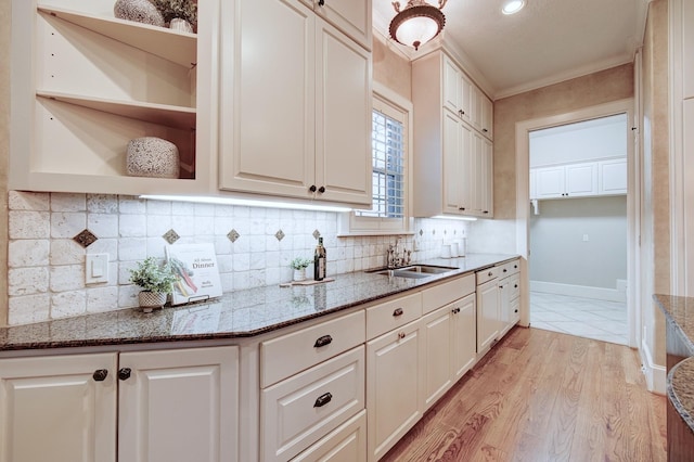 kitchen featuring a sink, stone countertops, tasteful backsplash, and white cabinets