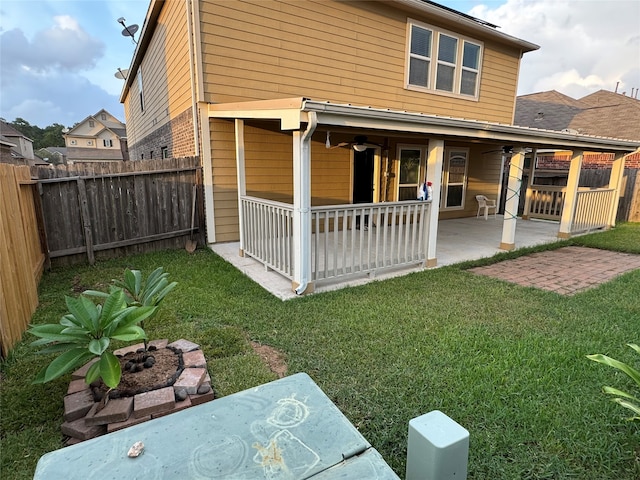 back of property featuring a yard, a patio, and ceiling fan