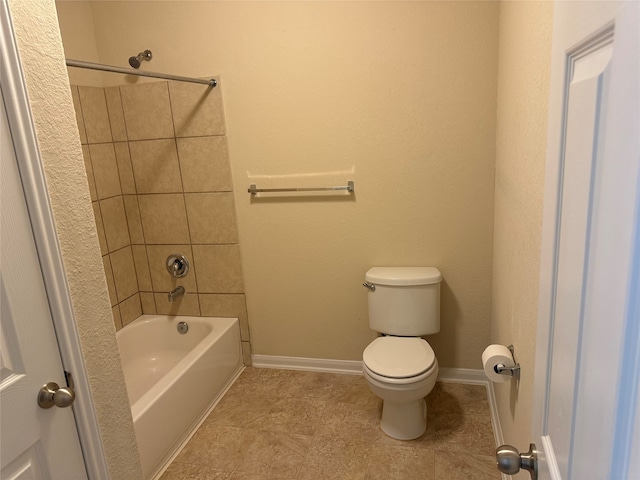 bathroom with toilet and tiled shower / bath combo